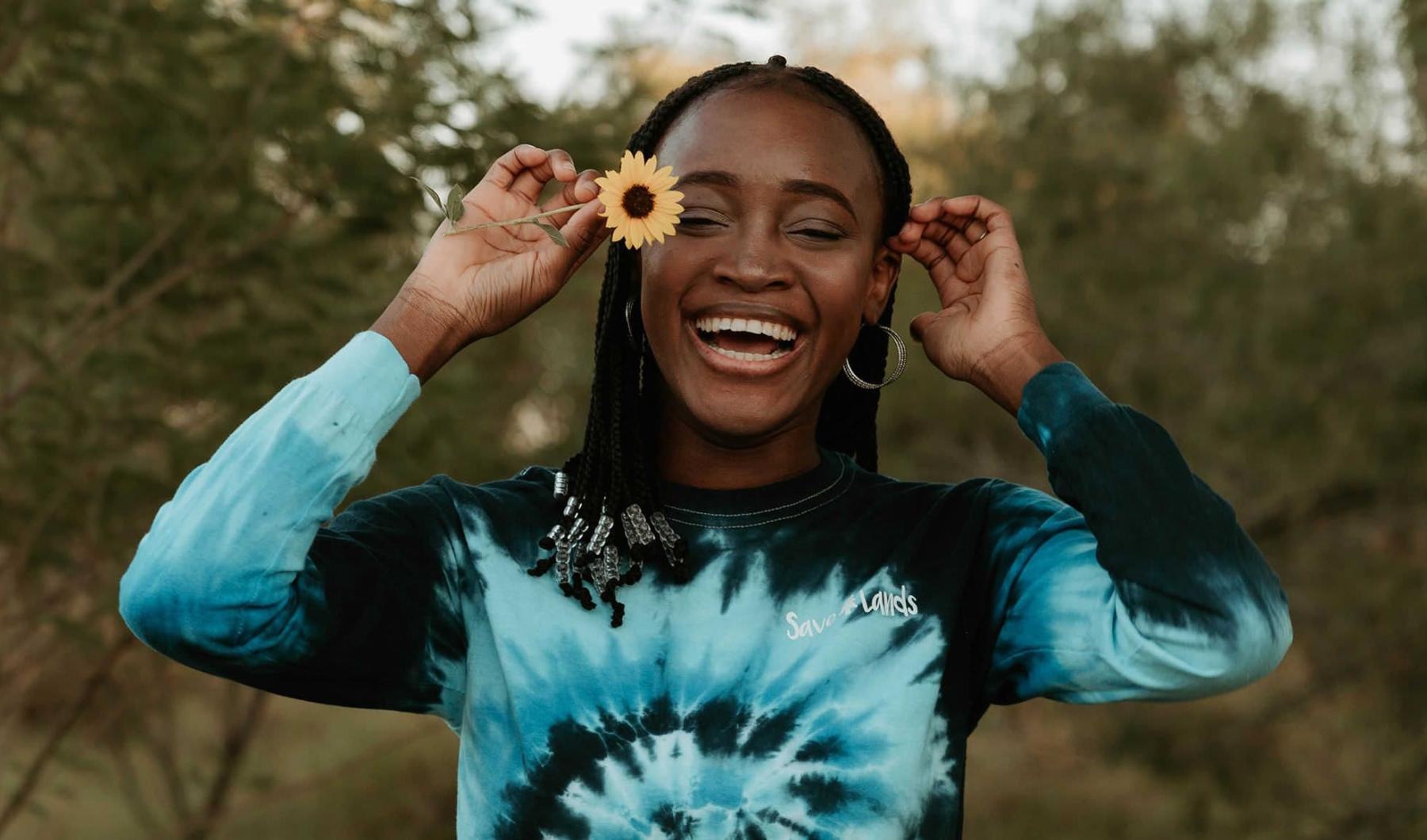A beautiful community at the heart of all your passions woman holds a flower in her hair in a park